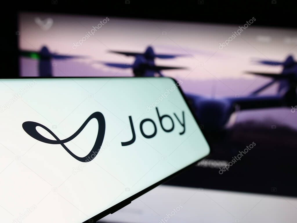 Stuttgart, Germany - 11-16-2023: Cellphone with logo of American eVTOL aircraft company Joby Aviation in front of business website. Focus on left of phone display.