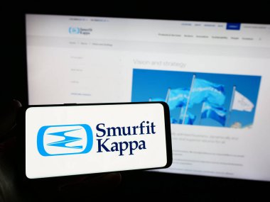 Stuttgart, Almanya - 11-16-2023: İrlandalı ambalaj şirketi Şirin Kappa Group plc 'nin logosuna sahip akıllı telefon sahibi kişi web sitesinin önünde. Telefon ekranına odaklan.