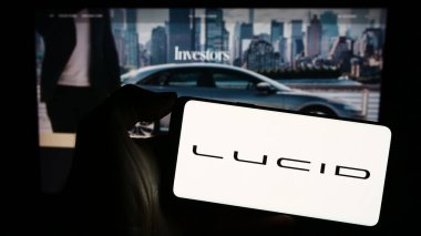 Stuttgart, Almanya - 11-17-2023: Üzerinde ABD 'li elektrikli araç şirketi Lucid Motors' un logosu bulunan cep telefonu sahibi kişi iş sayfasının önünde. Telefon ekranına odaklan.