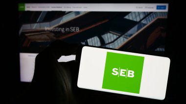 Stuttgart, Almanya - 11-17-2023: İnternet sitesi önünde İsveçli şirket Skandinaviska Enskilda Banken AB 'nin (SEB) logosuna sahip kişi. Telefon ekranına odaklan.