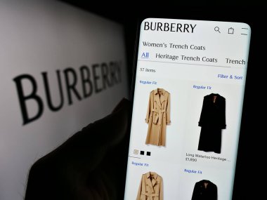 Stuttgart, Almanya - 11-21-2023: İngiliz lüks moda şirketi Burberry Group plc 'nin web sayfası bulunan akıllı telefon sahibi kişi logonun önünde. Telefon ekranının merkezine odaklan.