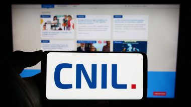 Stuttgart, Almanya - 11-21-2023: İnternet sayfasının önünde Komisyon Nationale de l 'Informatique et des Libertes (CNIL) logosu bulunan kişi. Telefon ekranına odaklan.