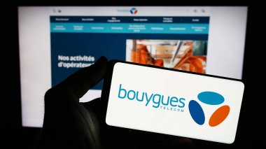 Stuttgart, Almanya - 11-22-2023: İnternet sitesi önünde üzerinde Fransız telekomünikasyon şirketi Bouygues Telecom S.A. logosu bulunan kişi. Telefon ekranına odaklan.