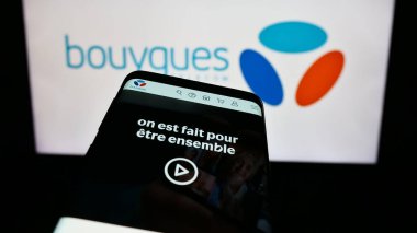 Stuttgart, Almanya - 11-22-2023: Fransız telekomünikasyon şirketi Bouygues Telecom SA 'nın web sitesiyle birlikte logo önünde cep telefonu. Telefon ekranının sol üst kısmına odaklan.