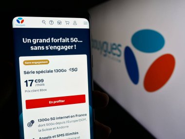 Stuttgart, Almanya - 11-22-2023: Fransız telekomünikasyon şirketi Bouygues Telecom S.A. 'nın logolu web sayfası ile akıllı telefon tutan kişi. Telefon ekranının merkezine odaklan.