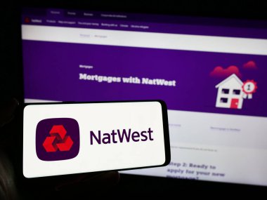 Stuttgart, Germany - 11-22-2023: Person holding smartphone with logo of financial company National Westminster Bank (NatWest) in front of website. Focus on phone display. clipart