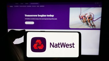 Stuttgart, Almanya - 11-22-2023: İnternet sayfası önünde finans şirketi National Westminster Bank 'ın (NatWest) logosuna sahip cep telefonu sahibi kişi. Telefon ekranına odaklan.