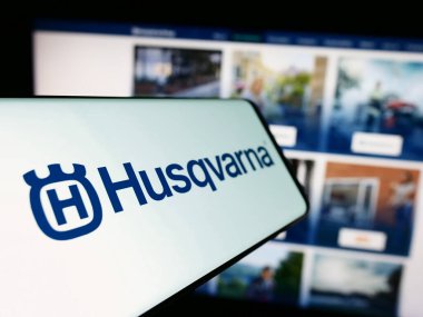 Stuttgart, Almanya - 11-22-2023: İsveçli elektrik ürünleri şirketi Husqvarna AB 'nin logosunun yer aldığı cep telefonu, işletme web sitesi önünde. Telefon ekranının merkez soluna odaklan.