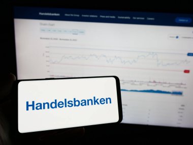 Stuttgart, Almanya - 11-22-2023: İsveçli finans şirketi Svenska Handelsbanken AB 'nin logosunu taşıyan cep telefonu sahibi şirket web sitesi önünde. Telefon ekranına odaklan.