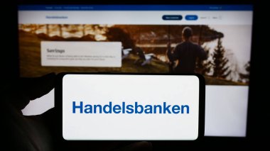 Stuttgart, Almanya - 11-22-2023: İsveçli finans şirketi Svenska Handelsbanken AB 'nin logosunu taşıyan cep telefonu sahibi şirket web sitesi önünde. Telefon ekranına odaklan.