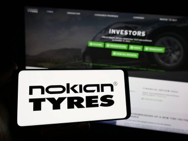 Stuttgart, Almanya - 11-22-2023: İnternet sitesinin önünde Fin lastik imalat şirketi Nokian Lastiklerinin logosuna sahip akıllı telefon sahibi kişi. Telefon ekranına odaklan.