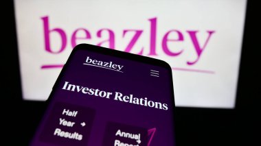 Stuttgart, Almanya - 11-22-2023: İngiliz sigorta şirketi Beazley plc 'nin web sitesi ile birlikte ticari logonun önünde akıllı telefon. Telefon ekranının sol üst kısmına odaklan.