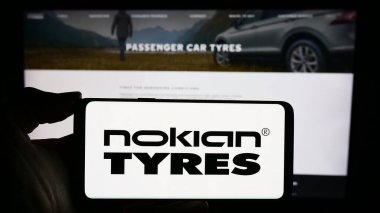 Stuttgart, Almanya - 11-22-2023: Fin lastik imalat şirketi Nokian Tyres 'ın logosunu taşıyan cep telefonu sahibi şirket web sitesi önünde. Telefon ekranına odaklan.