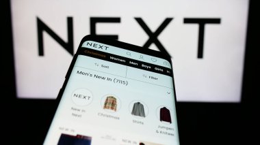 Stuttgart, Almanya - 11-23-2023: İngiliz giyim perakende şirketi Next plc 'in web sayfası ile birlikte cep telefonu. Telefon ekranının sol üst kısmına odaklan.