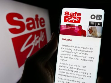 Stuttgart, Almanya - 11-24-2023: İngiliz pencere şirketi Safestyle UK plc 'nin web sayfası olan cep telefonu sahibi iş logosu önünde. Telefon ekranının merkezine odaklan.