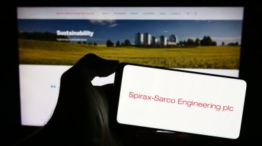 Stuttgart, Almanya - 11-24-2023: İngiliz Spirax-Sarco Engineering plc şirketinin logosuna sahip akıllı telefon sahibi kişi web sitesinin önünde. Telefon ekranına odaklan.