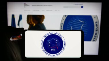 Stuttgart, Almanya - 11-27-2023: İnternet sayfasının önünde Yön Generali de la Securite Interieure (DGSI) logosu bulunan cep telefonu sahibi kişi. Telefon ekranına odaklan.