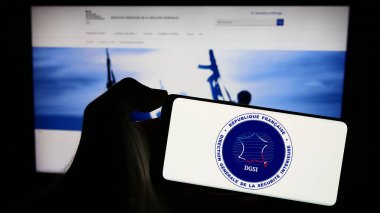 Stuttgart, Almanya - 11-27-2023: İnternet sayfası önünde Yön Generali de la Securite Interieure (DGSI) logosu bulunan cep telefonu sahibi kişi. Telefon ekranına odaklan.