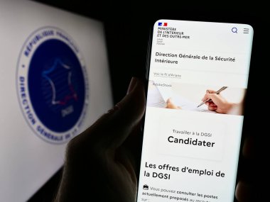 Stuttgart, Almanya - 11-27-2023: Logolu Direction Generale de la Securite Interieure (DGSI) web sitesi bulunan cep telefonu sahibi kişi. Telefon ekranının merkezine odaklan.