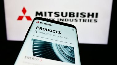 Stuttgart, Almanya - 11-28-2023: Japon Mitsubishi Heavy Industries Ltd. (MHI) şirketinin web sitesiyle birlikte logo önünde cep telefonu. Telefon ekranının sol üst kısmına odaklan.