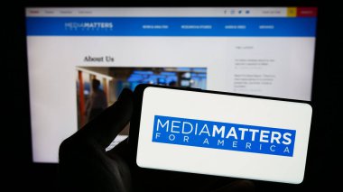 Stuttgart, Almanya - 11-28-2023: İnternet sitesi önünde ABD izleme grubu Media Matters for America 'nın (MMfA) logosunu taşıyan kişi. Telefon ekranına odaklan.