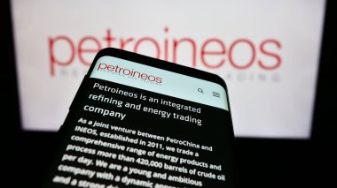 Stuttgart, Almanya - 11-28-2023: İngiliz petrol ve doğalgaz şirketi PetroIneos Trading Limited 'in web sitesi ile birlikte ticaret logosu önünde akıllı telefon. Telefon ekranının sol üst kısmına odaklan.