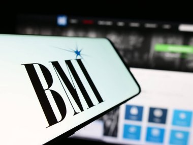 Stuttgart, Almanya - 11-29-2023: İnternet sitesinin önünde Amerikan performans hakları şirketi Broadcast Music Inc. (BMI) logosu bulunan cep telefonu. Telefon ekranının merkez soluna odaklan.
