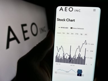 Stuttgart, Almanya - 11-30-2023: Amerikan perakende şirketi American Eagle Outfitters Inc. (AEO) 'nun logolu web sayfası ile cep telefonu tutan kişi. Telefon ekranının merkezine odaklan.