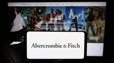 Stuttgart, Almanya - 11-30-2023: ABD 'li giyim perakende şirketi Abercrombie and Fitch Co' nun logosuna sahip akıllı telefon sahibi kişi web sitesinin önünde. Telefon ekranına odaklan.