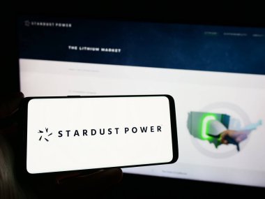 Stuttgart, Almanya - 11-30-2023: Üzerinde Amerikan lityum arıtma şirketi Stardust Power Inc. 'in logosu bulunan cep telefonu sahibi kişi web sayfasının önünde. Telefon ekranına odaklan.