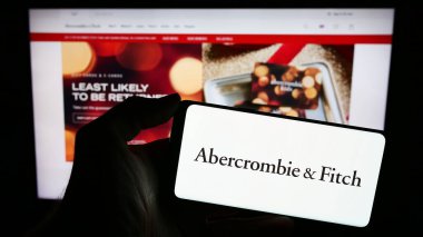 Stuttgart, Almanya - 11-30-2023: Üzerinde Amerikan giyim perakende şirketi Abercrombie and Fitch Co 'nun logosu bulunan cep telefonu sahibi kişi web sayfasının önünde. Telefon ekranına odaklan.