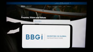 Stuttgart, Almanya - 12-02-2023: Yatırım şirketi BBGI Global Altyapı S.A. 'nın logosuyla cep telefonu tutan kişi iş sayfası önünde. Telefon ekranına odaklan.