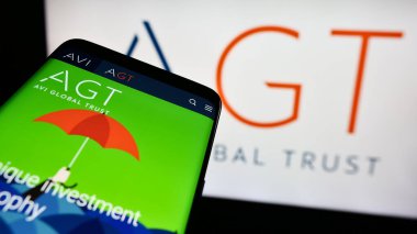 Stuttgart, Almanya - 12-02-2023: İngiliz yatırım şirketi AVI Global Trust plc 'in (AGT) web sitesiyle birlikte iş logosu önünde cep telefonu. Telefon ekranının sol üst kısmına odaklan.