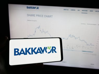 Stuttgart, Almanya - 12-02-2023: Gıda işleme şirketi Bakkavor Group plc 'nin logosunun bulunduğu cep telefonu sahibi kişi iş sayfasının önünde. Telefon ekranına odaklan.