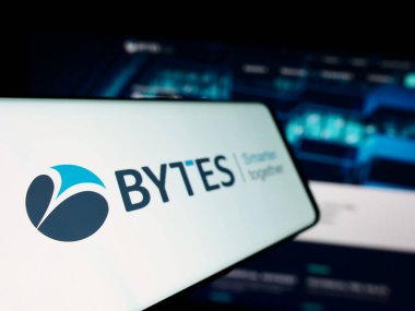 Stuttgart, Germany - 12-05-2023: Smartphone with logo of British software company Bytes Technology Group plc in front of business website. Focus on left of phone display. clipart