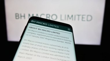 Stuttgart, Almanya - 12-05-2023: Yatırım şirketi BH Macro Limited 'in web sitesine sahip akıllı telefon iş logosu önünde. Telefon ekranının sol üst kısmına odaklan.