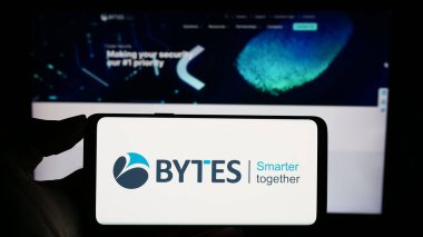 Stuttgart, Almanya - 12-05-2023: İngiliz yazılım şirketi Bytes Technology Group plc 'nin logosuyla cep telefonu tutan kişi iş sayfasının önünde. Telefon ekranına odaklan.