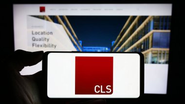 Stuttgart, Almanya - 12-06-2023: İngiliz gayrimenkul yatırım şirketi CLS Holding plc 'nin logosuna sahip cep telefonu sahibi kişi web sayfasının önünde. Telefon ekranına odaklan.