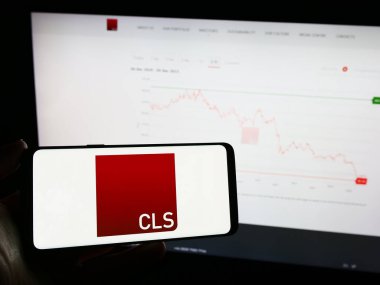 Stuttgart, Almanya - 12-06-2023: İngiliz gayrimenkul yatırım şirketi CLS Holding plc 'nin logosuna sahip cep telefonu sahibi kişi web sayfasının önünde. Telefon ekranına odaklan.