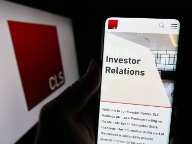 Stuttgart, Almanya - 12-06-2023: İngiliz emlak yatırım şirketi CLS Holding plc ile logolu cep telefonu tutan kişi. Telefon ekranının merkezine odaklan.