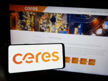 Stuttgart, Germany - 12-06-2023: Person holding cellphone with logo of British fuel cell company Ceres Power Holdings plc in front of business webpage. Focus on phone display. clipart