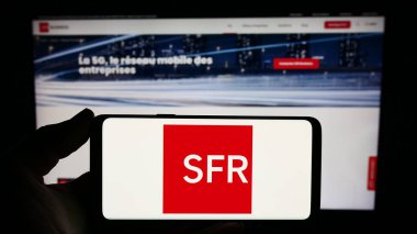 Stuttgart, Almanya - 12-07-2023: İnternet sitesi önünde üzerinde Fransız Societe Francaise du Radiotelephone (SFR) logosu bulunan kişi. Telefon ekranına odaklan.