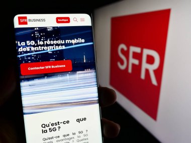 Stuttgart, Almanya - 12-07-2023: Fransız Societe Francaise du Radiotelephone (SFR) şirketinin logolu web sayfası ile cep telefonu tutan kişi. Telefon ekranının merkezine odaklan.