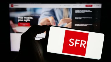 Stuttgart, Almanya - 12-07-2023: İnternet sayfası önünde Fransız Societe Francaise du Radiotelephone (SFR) logosunun bulunduğu cep telefonu sahibi kişi. Telefon ekranına odaklan.