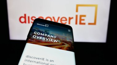 Stuttgart, Almanya - 12-08-2023: İngiliz elektronik şirketi Discovery IE Group plc 'in web sitesinin bulunduğu cep telefonu, iş logosu önünde. Telefon ekranının sol üst kısmına odaklan.