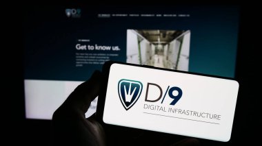 Stuttgart, Almanya - 12-08-2023: İngiliz Digital 9 Altyapı plc (D9) şirketinin logosuna sahip akıllı telefon sahibi kişi web sitesi önünde. Telefon ekranına odaklan.