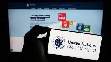 Stuttgart, Almanya - 12-09-2023: Web sitesi önünde BM Paktı Global Compact logosu taşıyan kişi. Telefon ekranına odaklan.