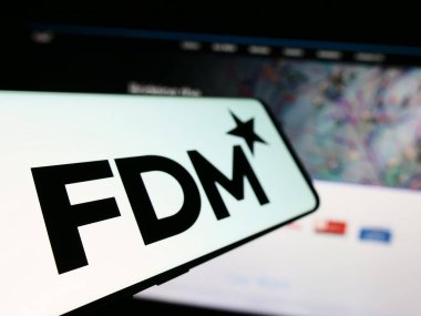 Stuttgart, Almanya - 12-09-2023: İngiliz bilgi teknolojileri şirketi FDM Group Limited 'in logosunun yer aldığı cep telefonu, işletme web sitesi önünde. Telefon ekranının soluna odaklan.
