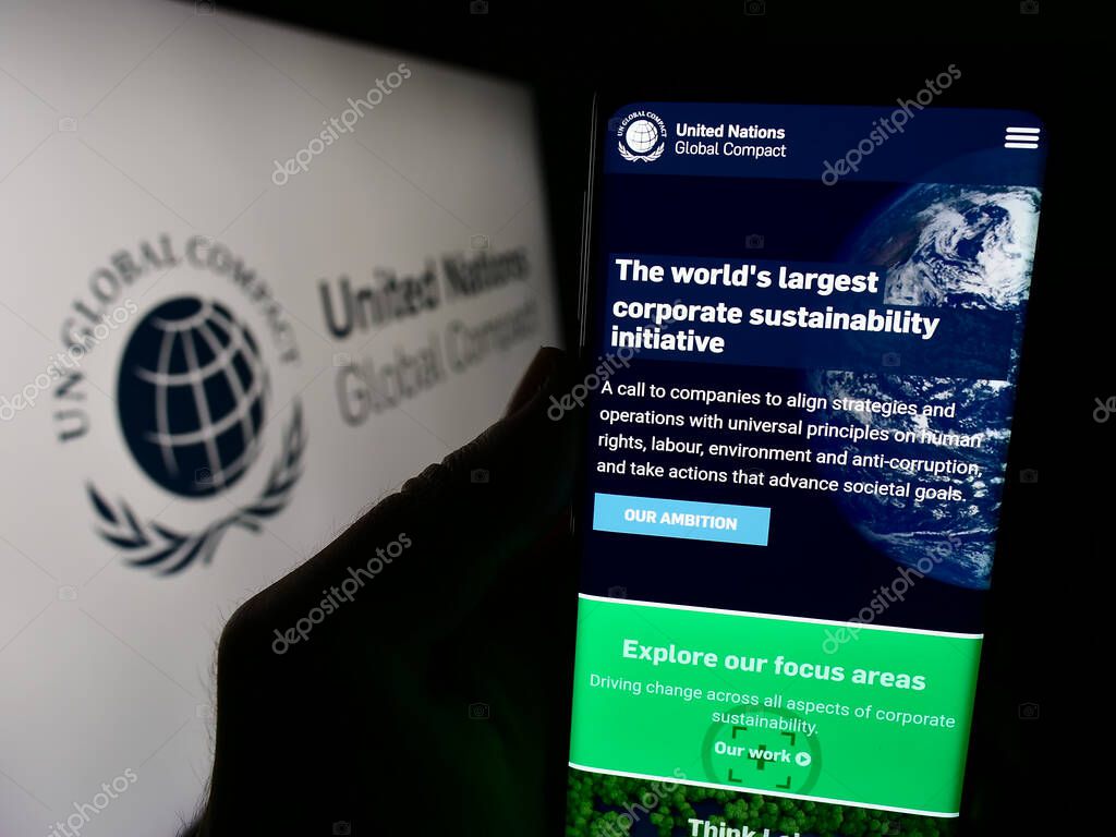 Stuttgart, Germany - 12-09-2023: Person holding cellphone with webpage of UN pact United Nations Global Compact in front of logo. Focus on center of phone display.