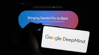 Stuttgart, Almanya - 12-14-2023: Yapay Zeka şirketi Google DeepMind 'ın logosu olan cep telefonu sahibi kişi iş sayfasının önünde. Telefon ekranına odaklan.